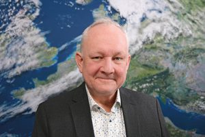 Porträt Doktor Andreas Walter vor der Rückwand mit dem Motiv Satellitenbild (Quelle DWD)