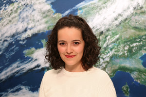 Portrait Maria Carvalho vor der Rückwand mit dem Motiv Satellitenbild (Quelle DWD)