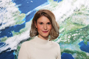 Porträt von Teresa Grimm vor der Rückwand mit dem Motiv Satellitenbild (Quelle DWD)